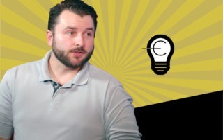Bearded man in a light polo sits against a yellow sunburst backdrop with a light bulb icon.