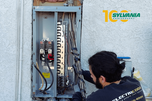 Electrician works on an outdoor electrical service panel/disconnect.