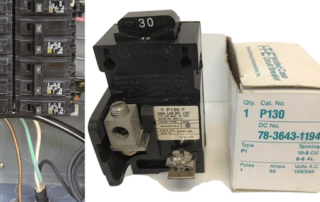Close-up of a circuit breaker and wiring; a boxed component sits against the panel.