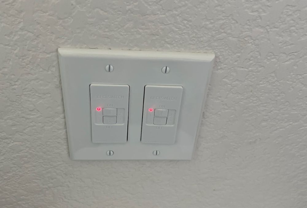 image_5 Close-up of a white double light switch plate on the wall.